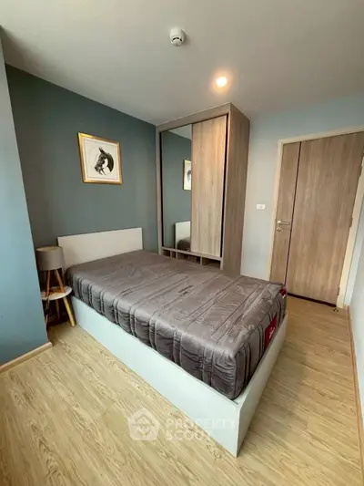 Modern bedroom with stylish decor and wooden flooring in a cozy apartment.