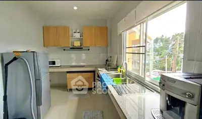 Modern kitchen with large window, sleek appliances, and ample counter space in a bright, airy setting.