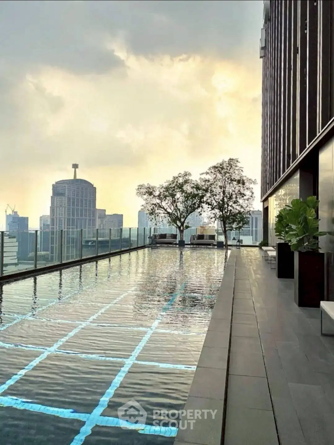 Stunning rooftop pool with city skyline view at sunset, perfect for luxury urban living.