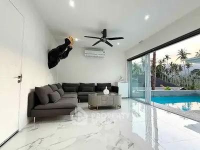Luxurious living room with pool view, modern furniture, and sleek marble flooring in tropical setting.