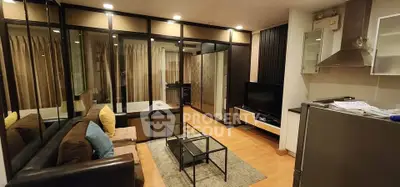 Modern living room with glass partitions and sleek furniture in a stylish apartment.