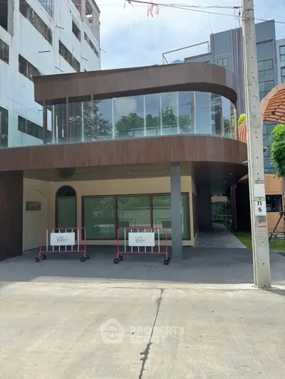 Modern commercial building exterior with large glass windows and sleek design.