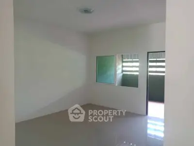 Spacious empty room with glossy floor and large window, ideal for customization.