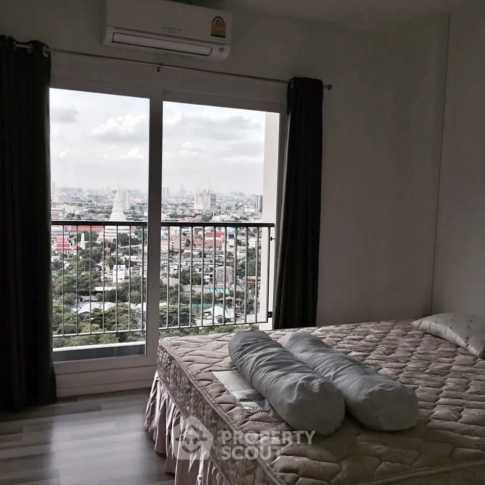 Spacious bedroom with stunning city view from large window in modern apartment.