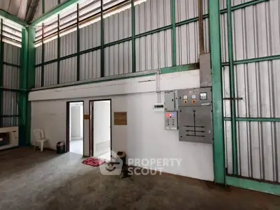 Spacious industrial warehouse interior with high ceilings and metal walls, ideal for storage or manufacturing.