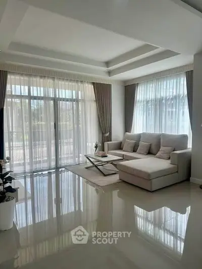 Spacious living room with elegant decor and large windows offering natural light.
