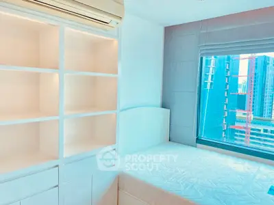 Modern bedroom with built-in shelves and city view window