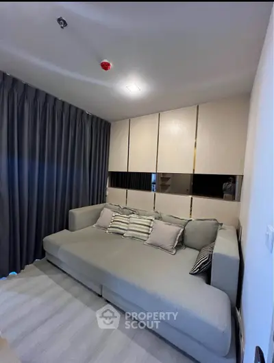 Modern living room with stylish sofa and elegant curtains in a cozy apartment setting.