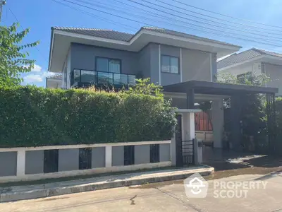 Modern two-story house with lush greenery and sleek design in a serene neighborhood.