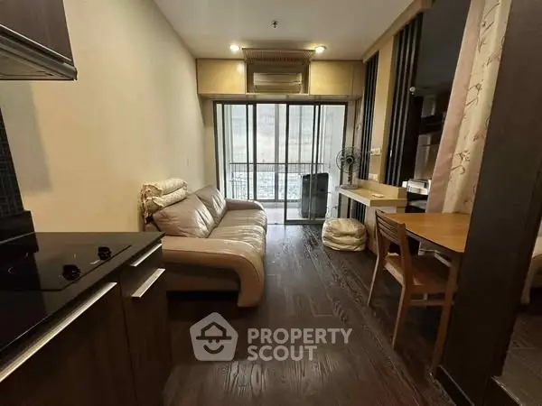 Cozy modern living room with balcony view and elegant wooden flooring.