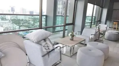 Stylish balcony with city view, modern seating, and elegant decor in high-rise building.