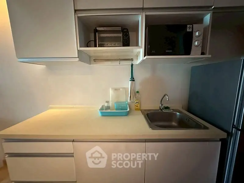 Modern kitchen with sleek cabinetry and appliances, featuring a compact design and efficient layout.