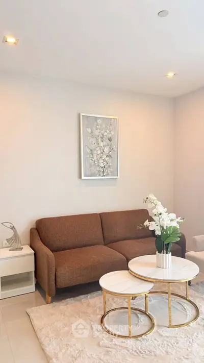 Elegant living room with modern brown sofa, chic nested tables, and stylish decor in a cozy setting.