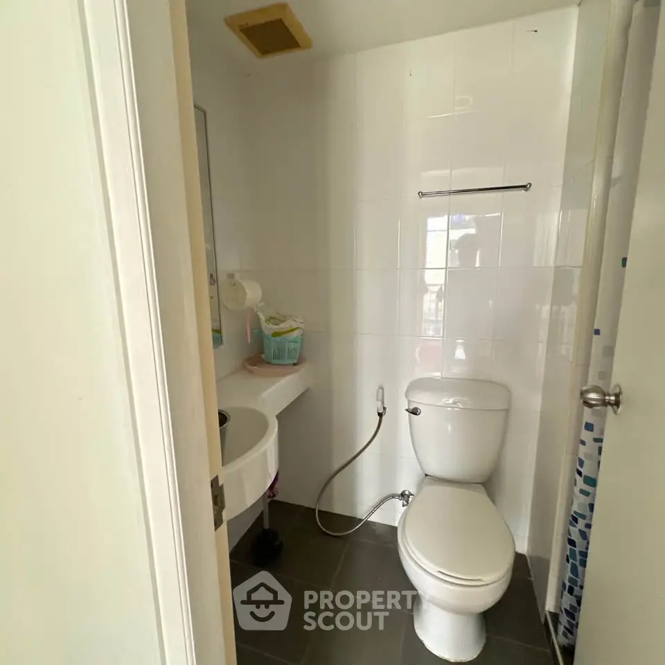 Compact bathroom with modern fixtures and tiled flooring in a cozy apartment.