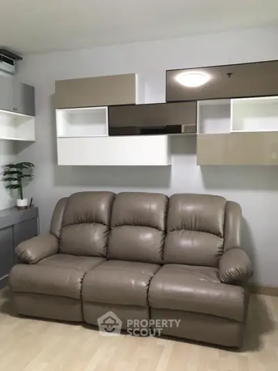 Modern living room with stylish wall-mounted shelves and comfortable leather sofa.