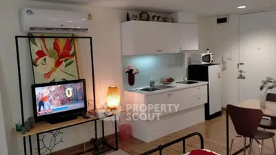Modern studio apartment with open kitchen and cozy living area, featuring stylish decor and efficient use of space.