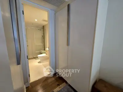 Modern bathroom with sleek design and glass shower enclosure in a contemporary apartment.