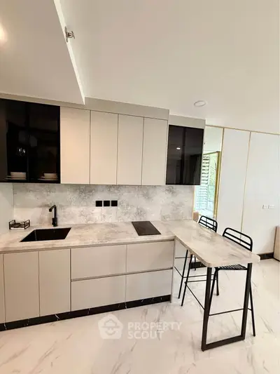 Modern kitchen with sleek cabinetry and breakfast bar in contemporary apartment