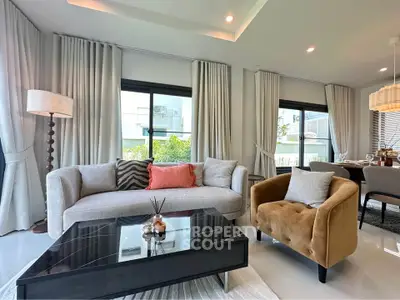 Elegant living room with modern furniture and large windows offering natural light.