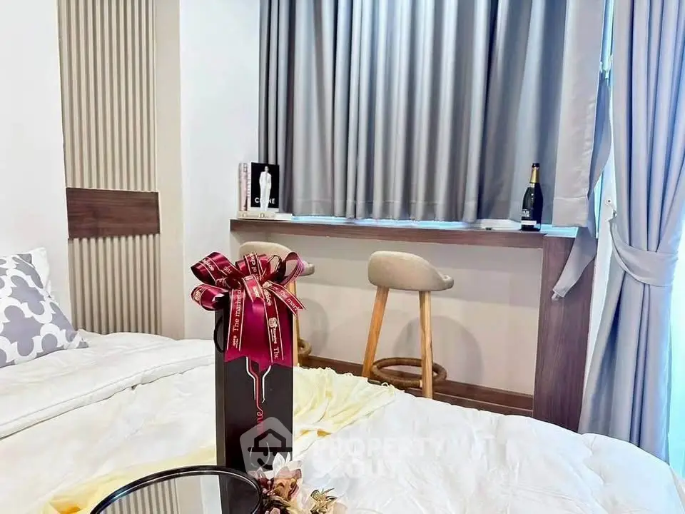 Cozy bedroom with elegant decor and stylish seating area by the window.