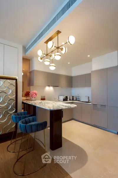 Modern kitchen with elegant marble island and stylish lighting in luxury apartment