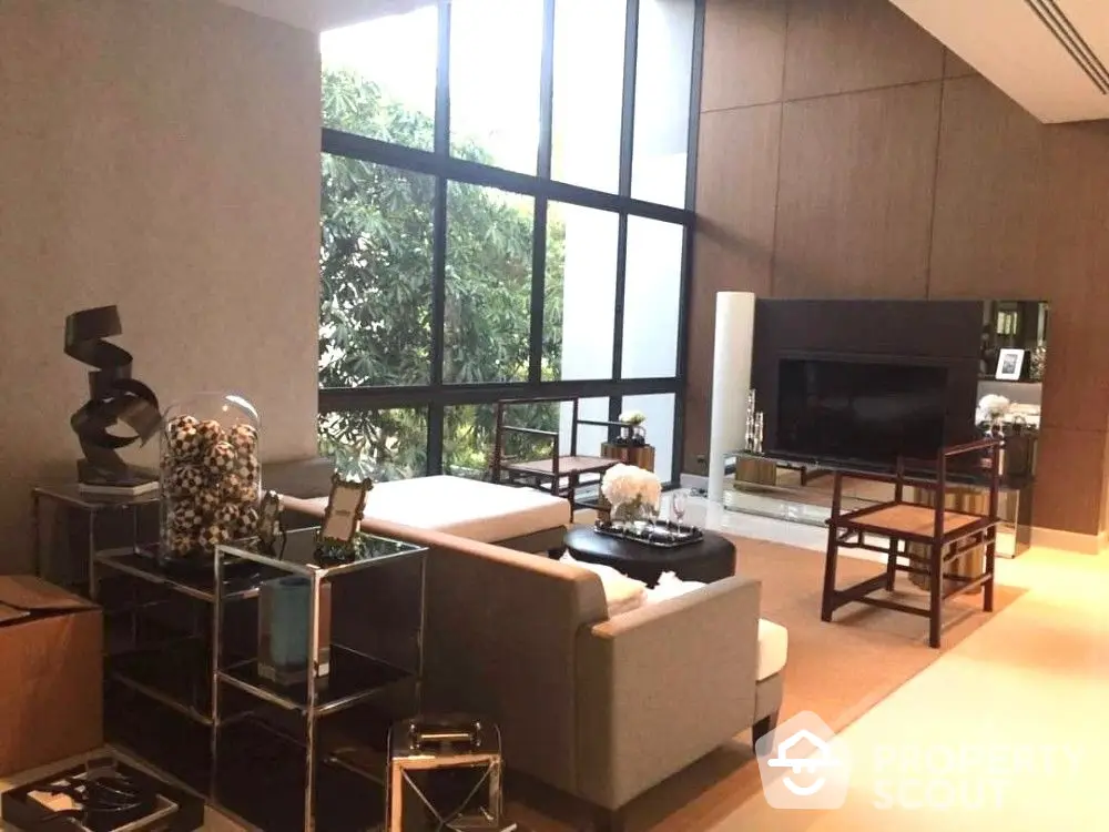 Luxurious living room with high ceilings, floor-to-ceiling windows offering lush garden views, modern furniture, and elegant decor.