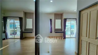 Spacious bedroom with mirrored closet and balcony view in modern apartment