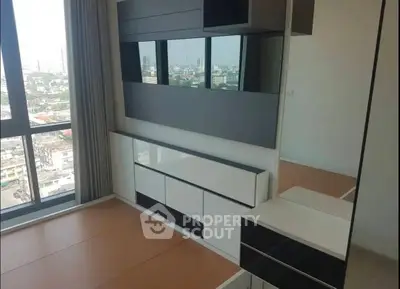Modern bedroom with large windows and built-in storage offering city views.