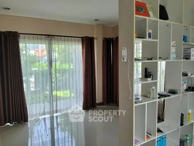 Spacious living room with large windows and modern shelving unit, perfect for natural light lovers.