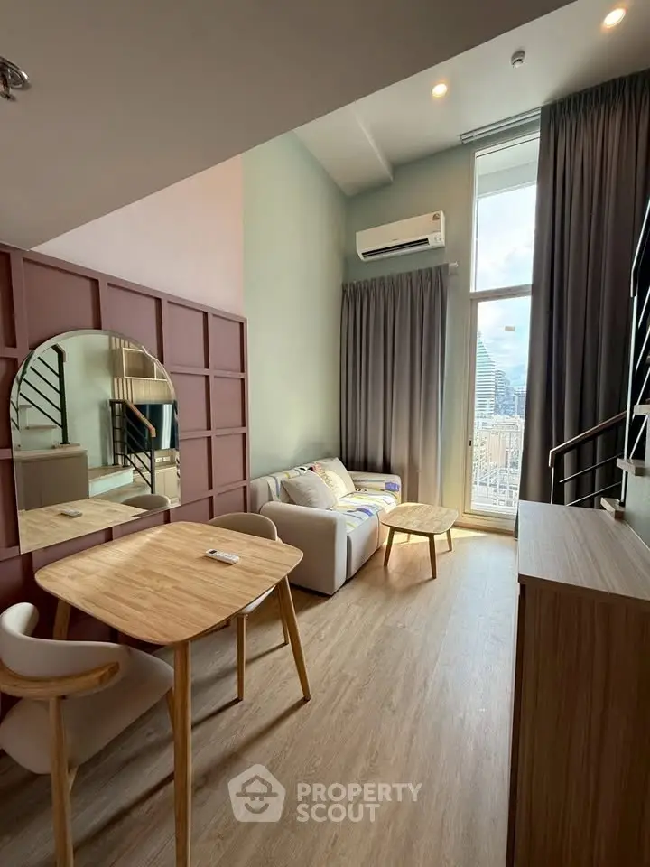 Modern living room with high ceiling and city view, featuring stylish furniture and natural light.