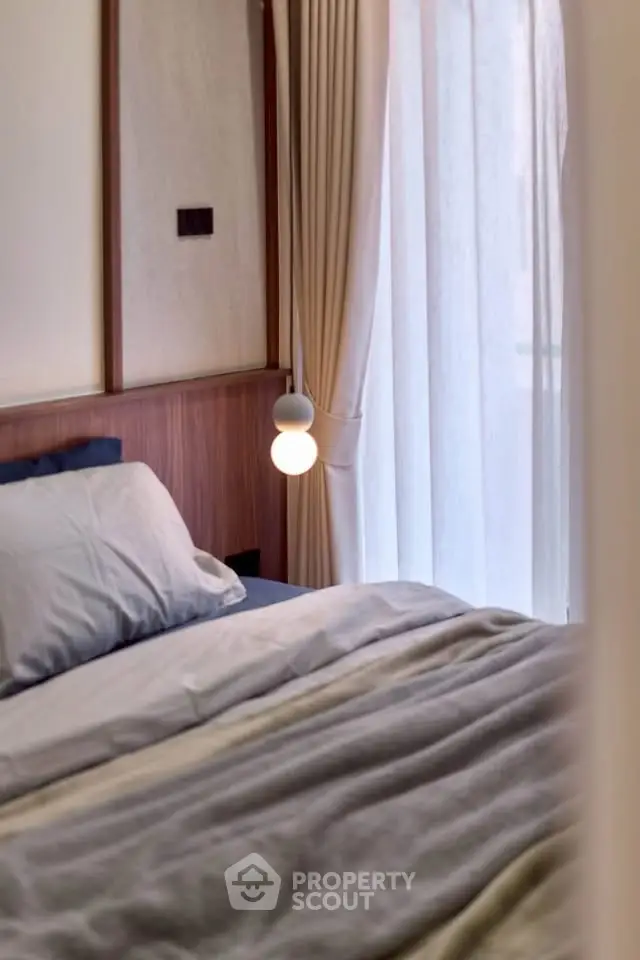 Cozy bedroom with elegant lighting and soft curtains, perfect for relaxation.