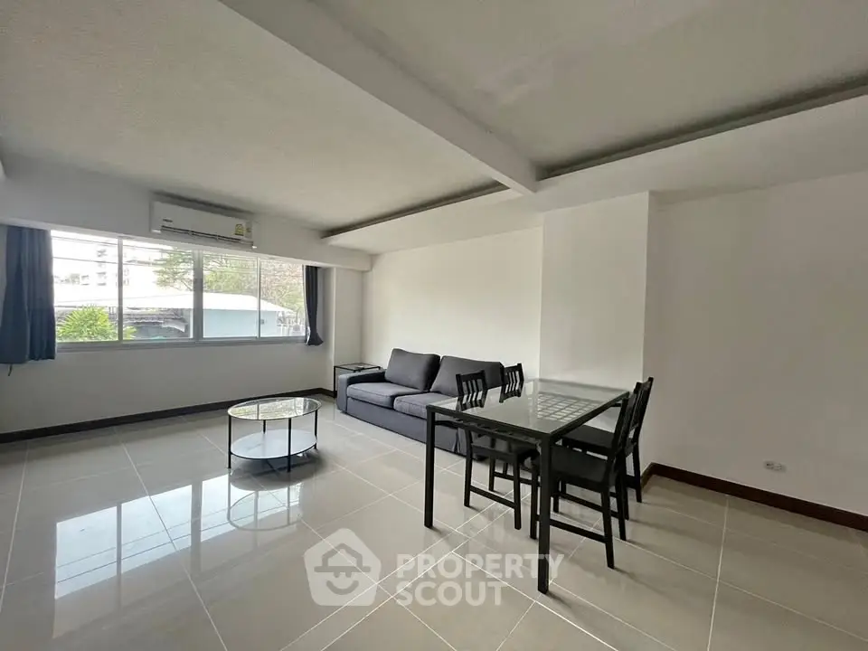 Spacious living room with modern furniture and large window for natural light.