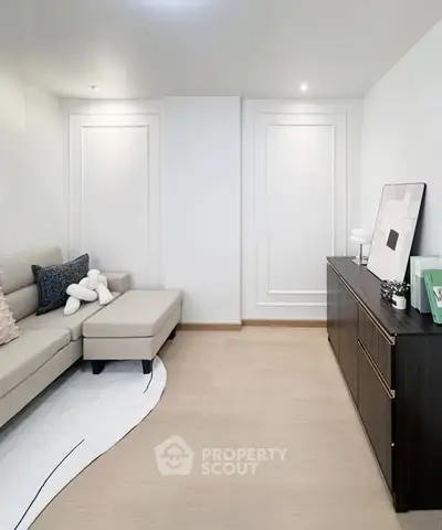 Modern living room with elegant decor and neutral tones, featuring a cozy sofa and stylish sideboard.