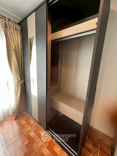 Spacious bedroom with modern built-in wardrobe and elegant curtains