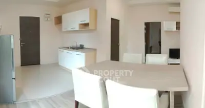 Modern open-plan kitchen and dining area with sleek furniture and neutral tones.