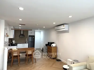 Modern open-layout kitchen and living area with sleek appliances and stylish furniture.