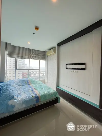 Modern bedroom with large window and city view, featuring wall-mounted TV bracket and air conditioning.