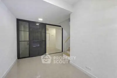 Modern minimalist interior with glass partition and staircase