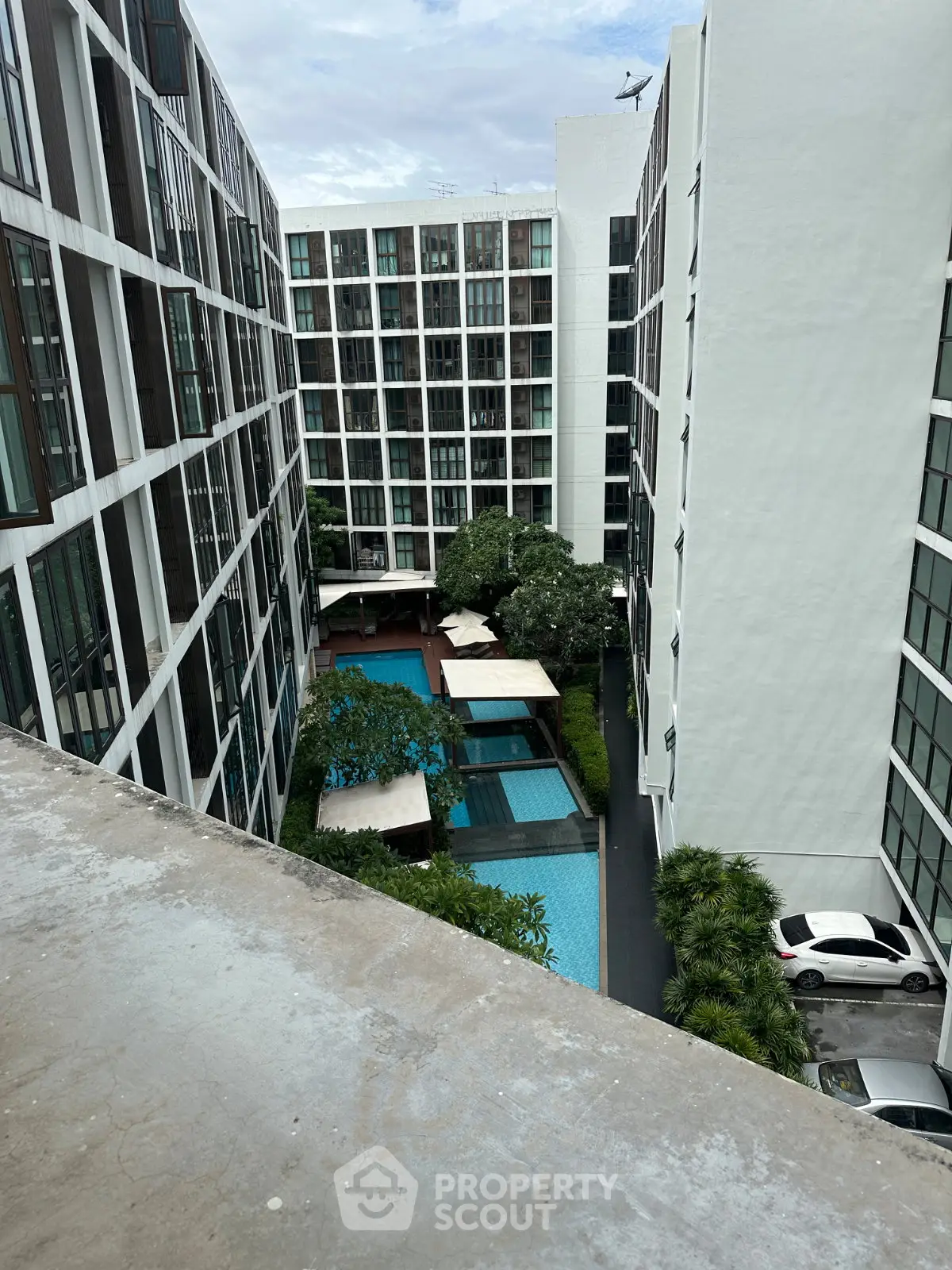 Modern apartment complex with pool view and lush greenery