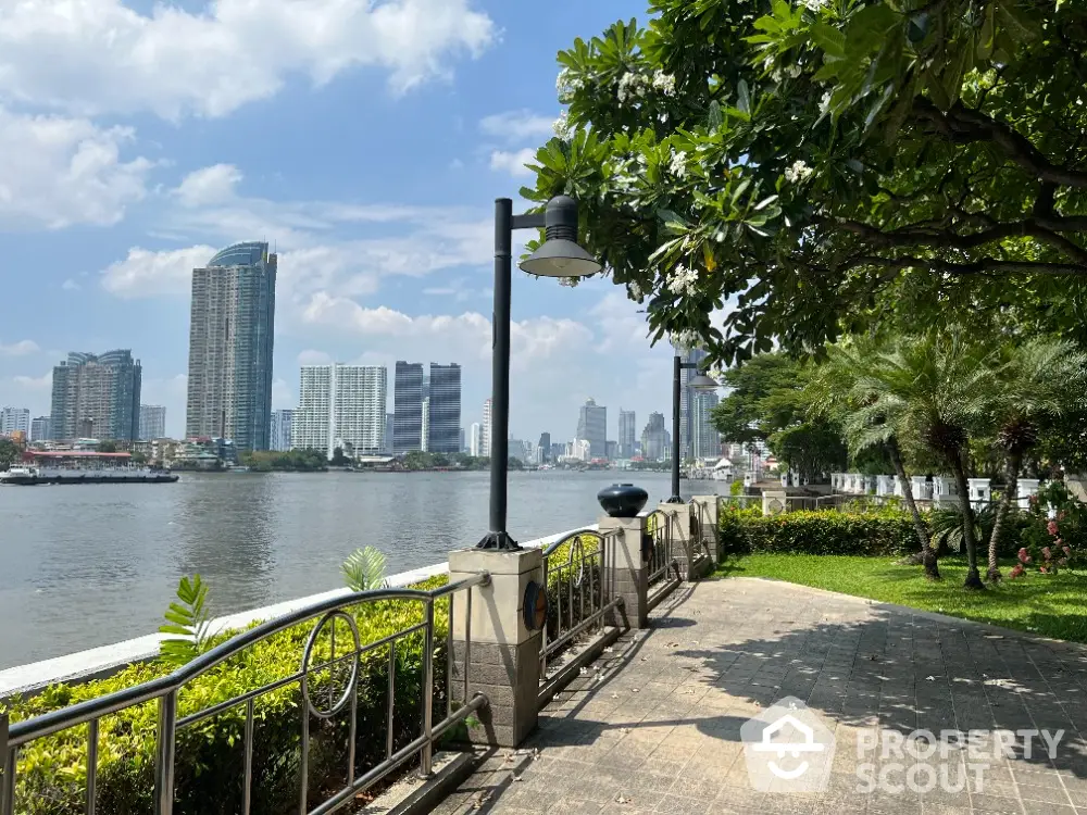 Scenic riverside view with lush greenery and city skyline, perfect for urban living.