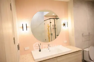 Modern bathroom with round mirror and stylish lighting