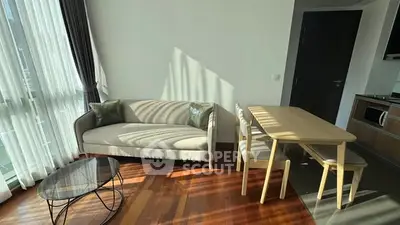 Modern living room with natural light, cozy sofa, and dining area in a stylish apartment.