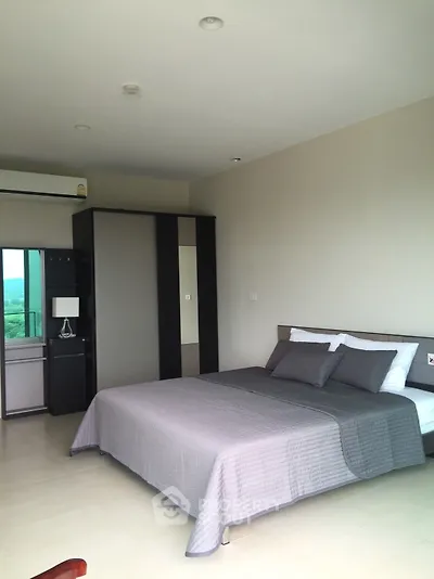 Spacious bedroom with modern design, large bed, and ample natural light from sliding glass doors leading to a balcony with a serene view.
