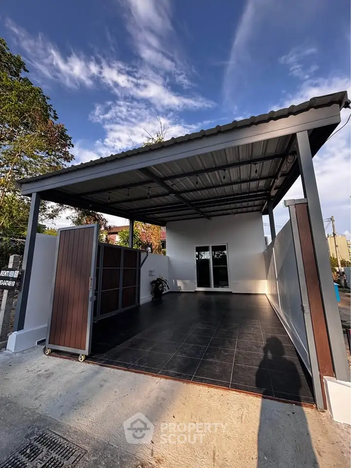Modern carport with sleek design and spacious driveway under a clear blue sky.