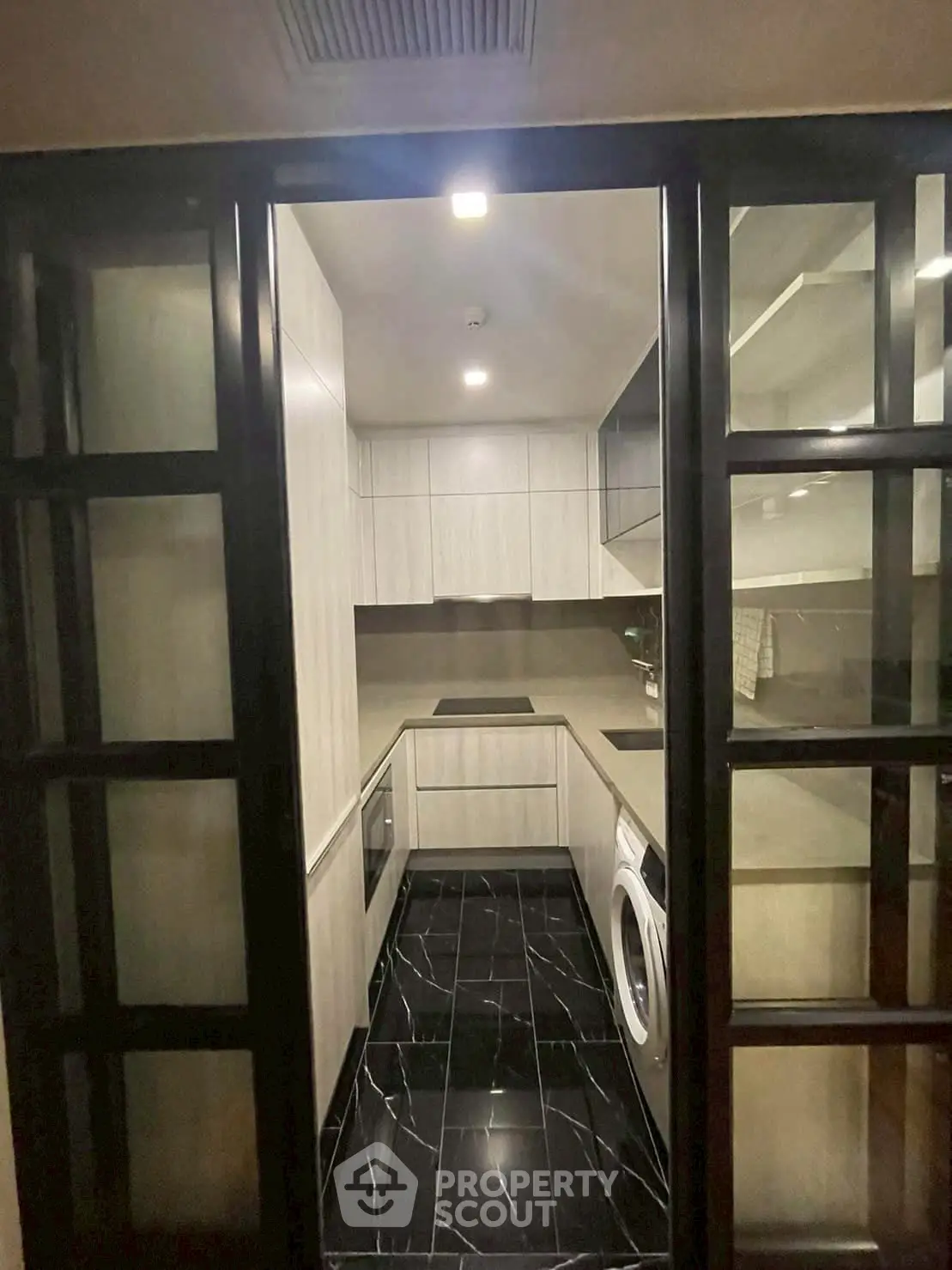 Modern compact kitchen with sleek black flooring and built-in appliances