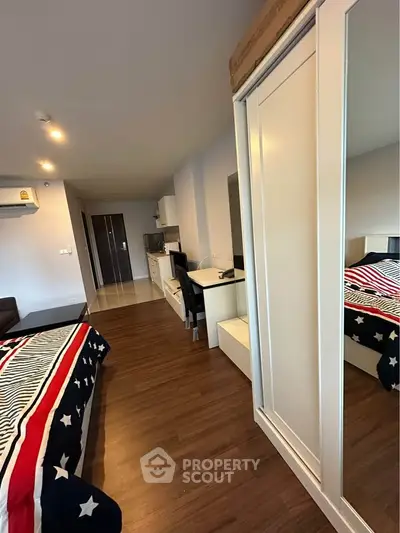 Modern bedroom with stylish decor and mirrored wardrobe in a cozy apartment.