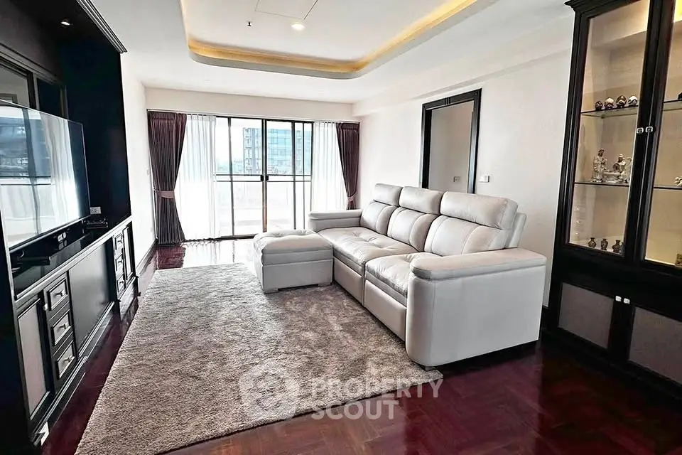 Spacious living room with modern sofa and large window offering city view.