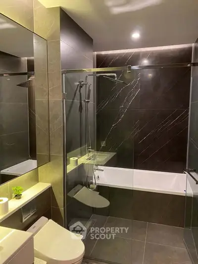 Luxurious modern bathroom with sleek dark tiles and glass shower enclosure