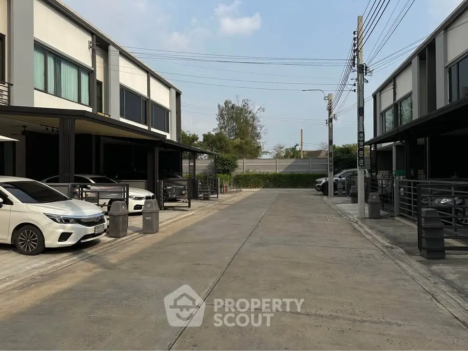 Modern townhouse complex with parking and sleek design in a suburban setting.
