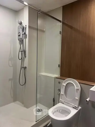 Modern bathroom with glass shower and sleek wooden accents